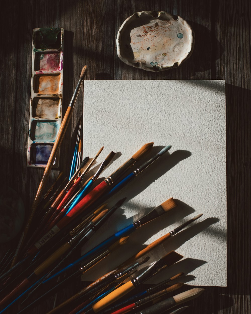 a bunch of paint brushes sitting on top of a paper