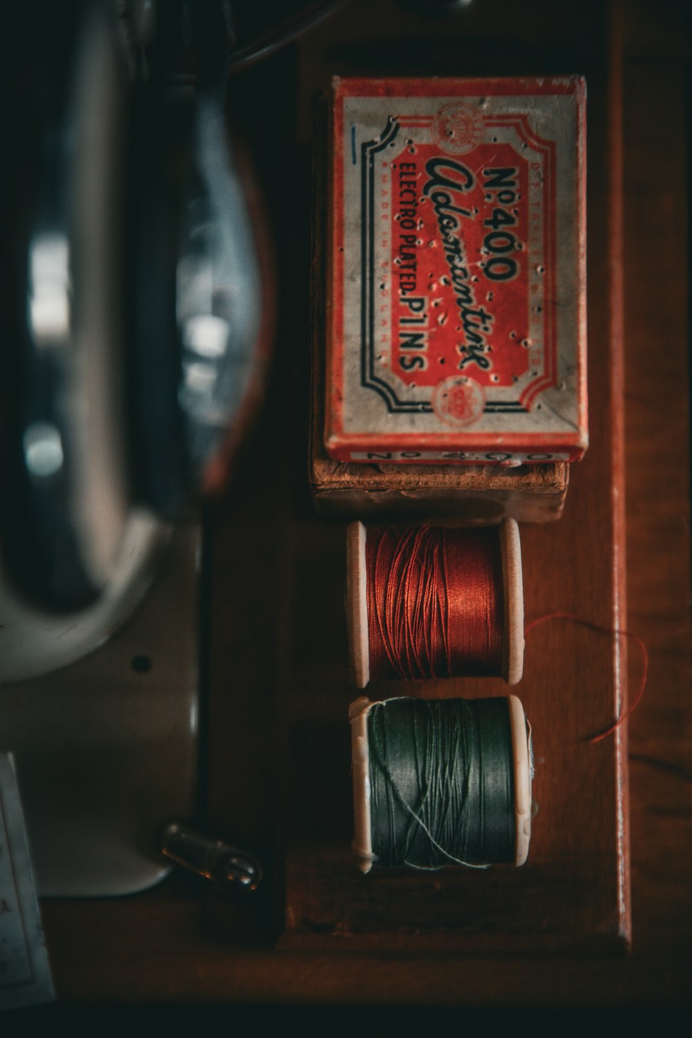 two spools of thread sitting on top of a wooden box