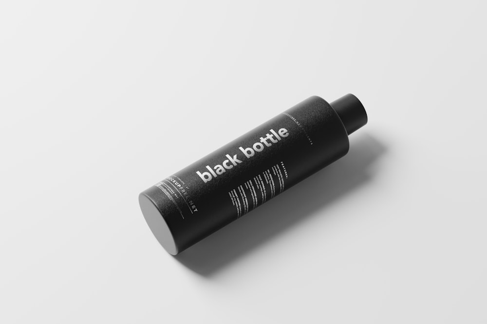 a tube of black bottle on a white surface