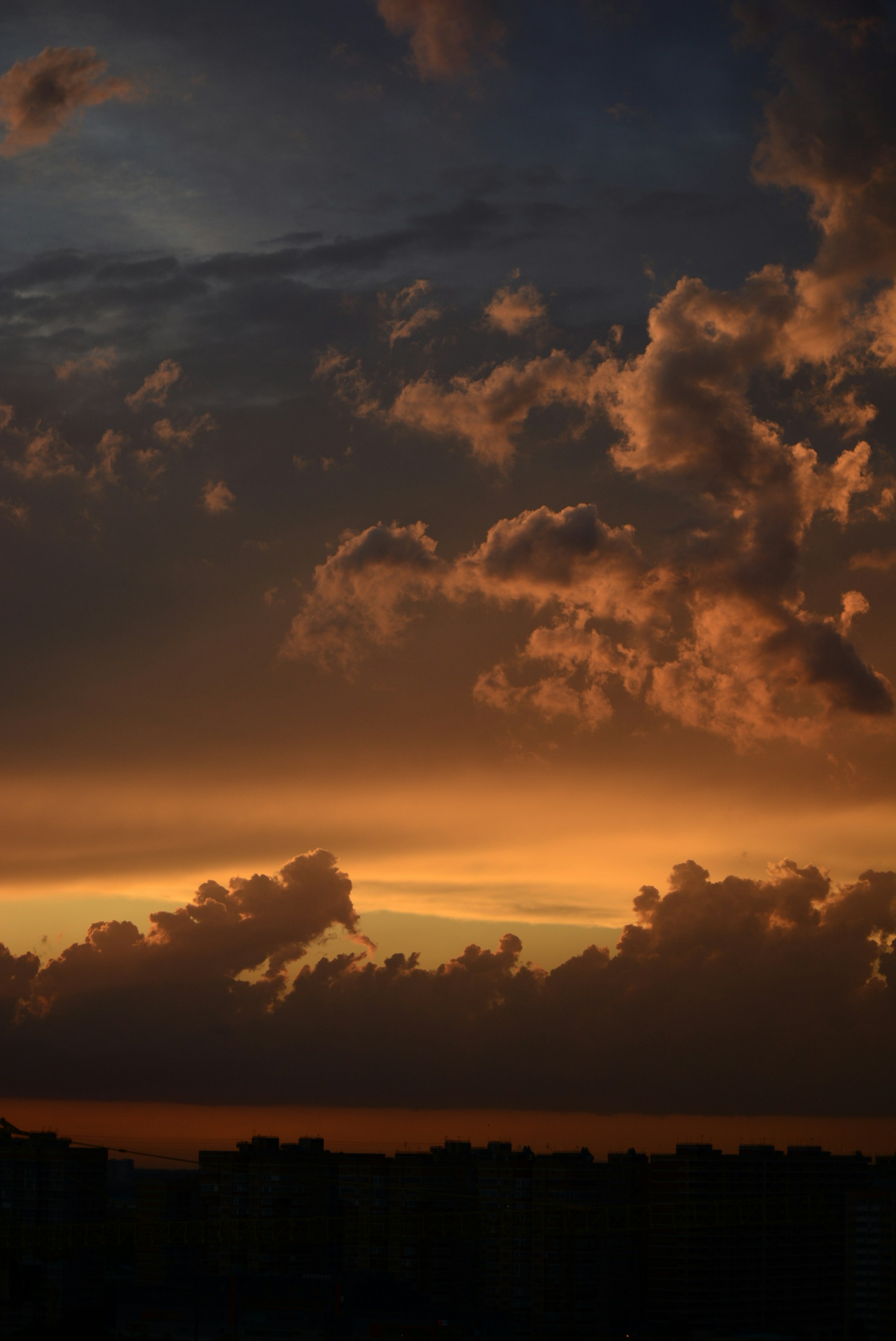a plane flying in the sky at sunset