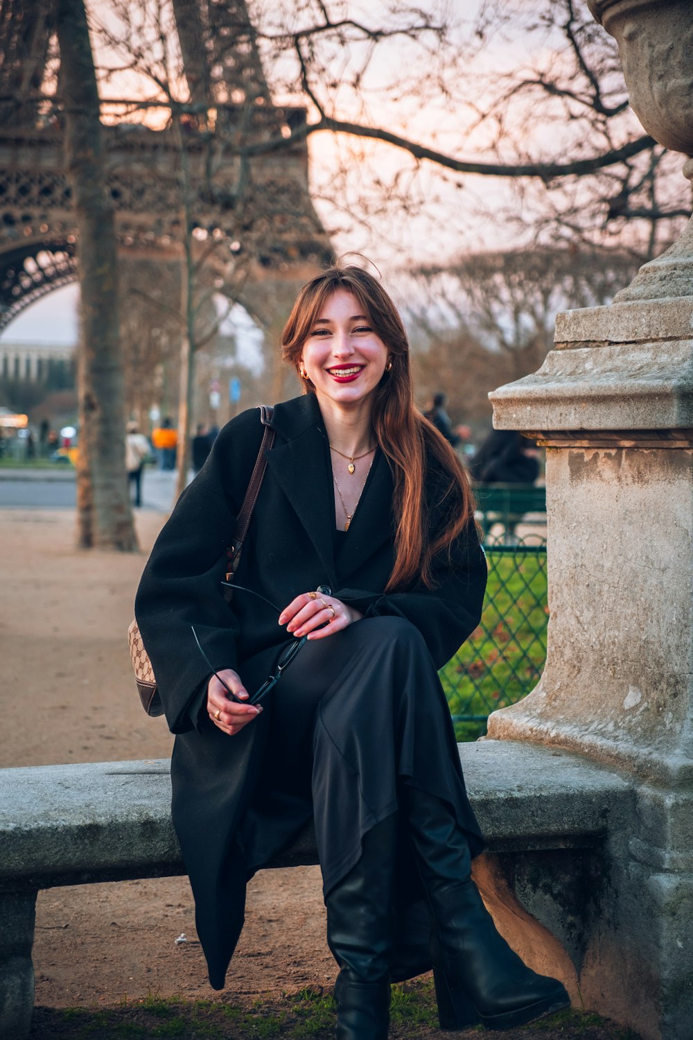 a woman sitting on a bench in a park