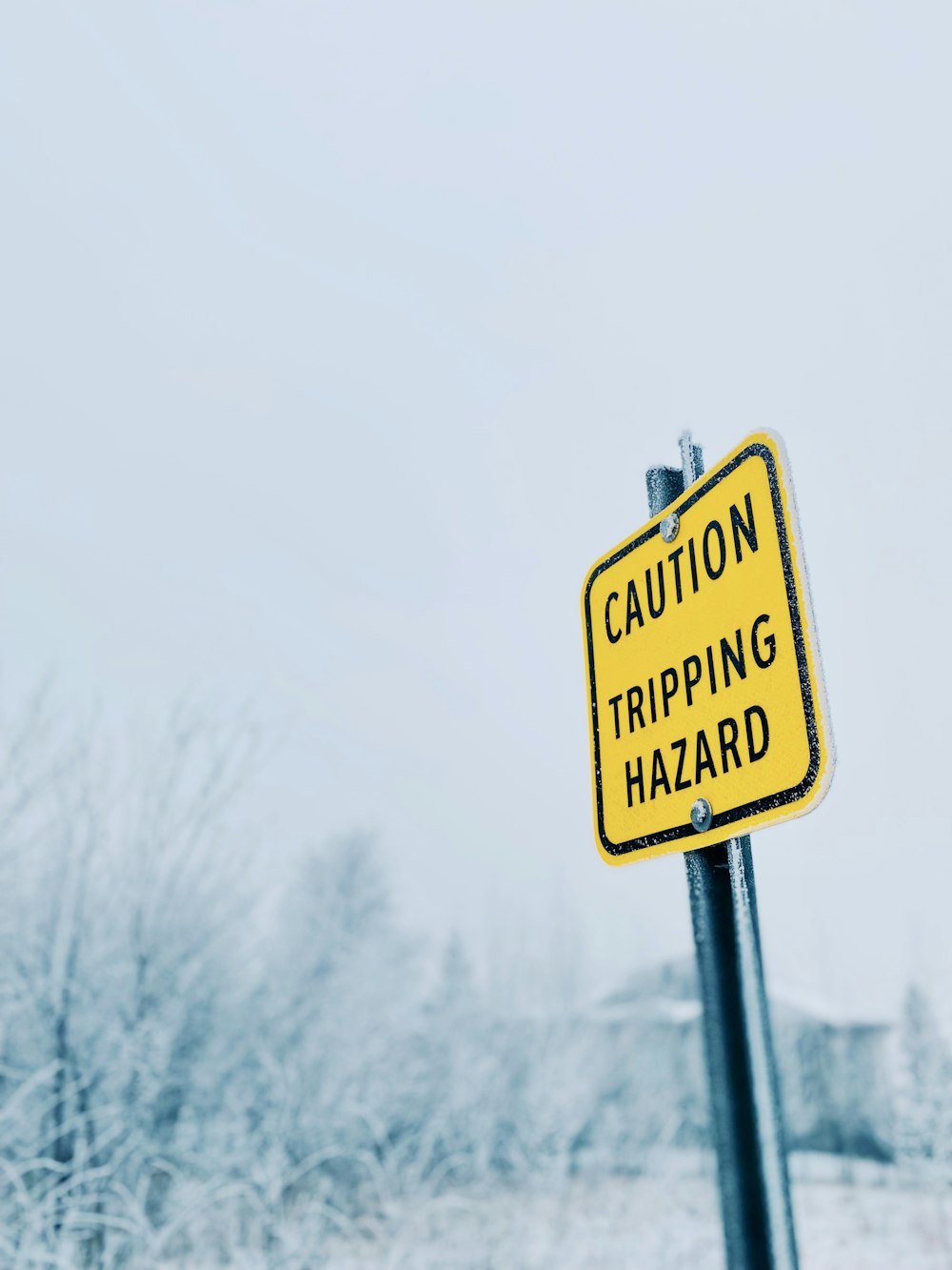 a caution tripping hazard sign on a pole