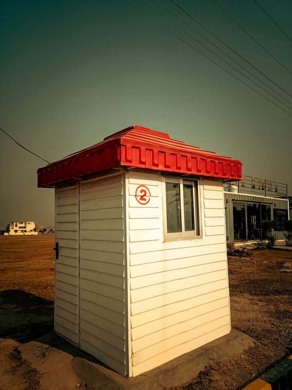 a small white building with a red roof