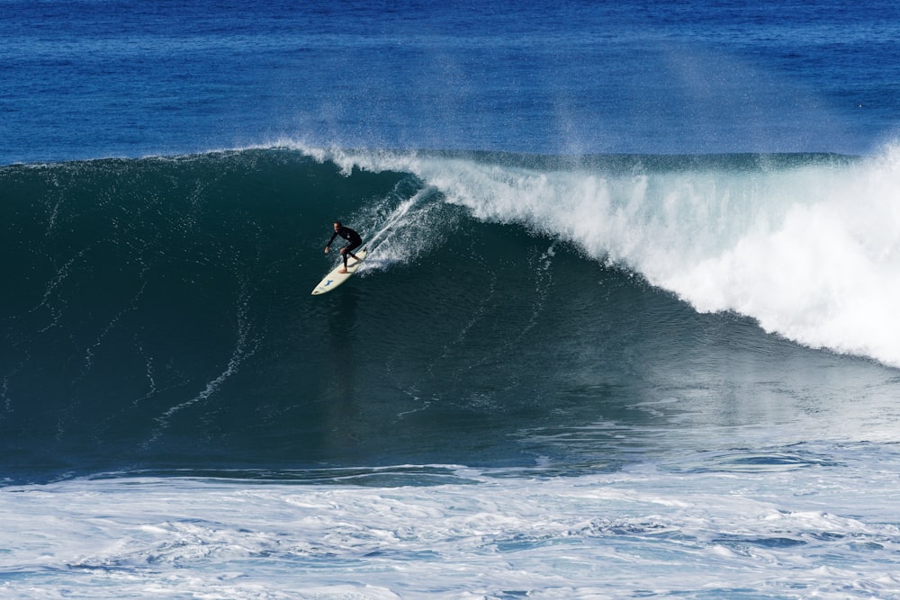 a man riding a wave on top of a surfboard