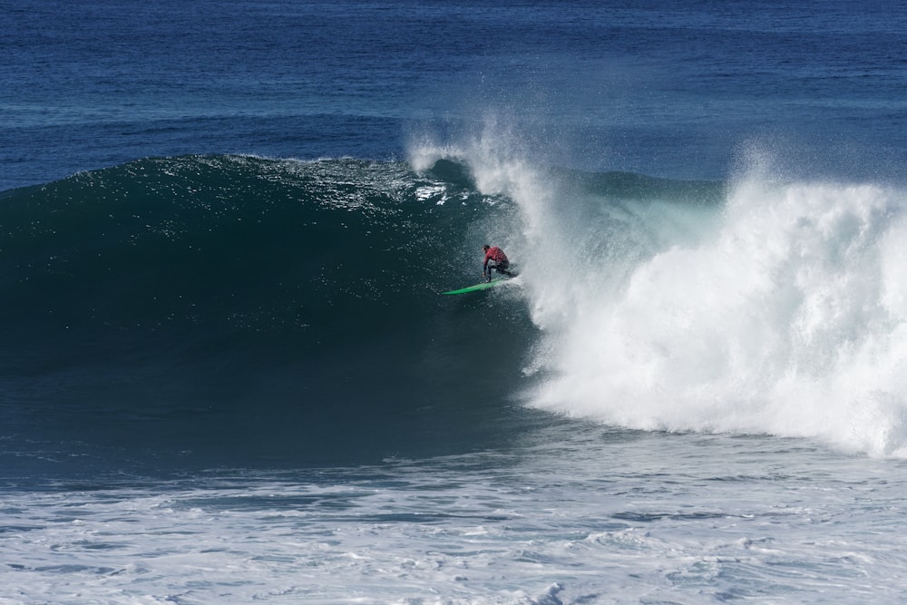 a man riding a wave on top of a surfboard