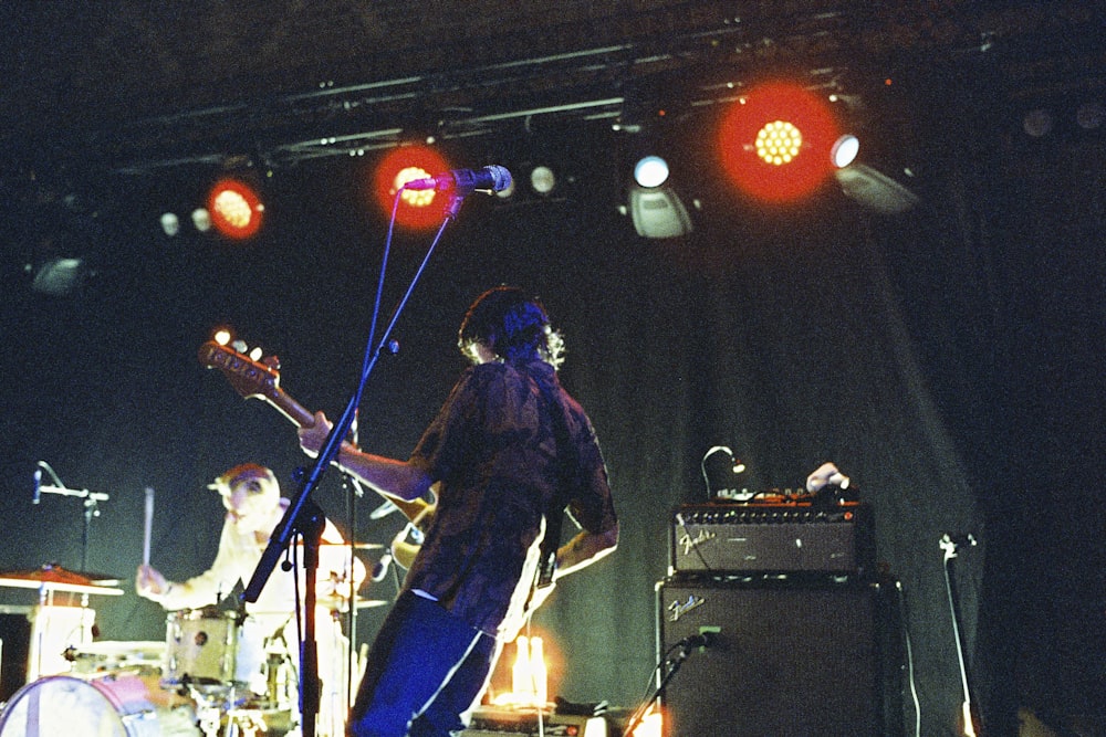 um homem em pé em um palco com um violão