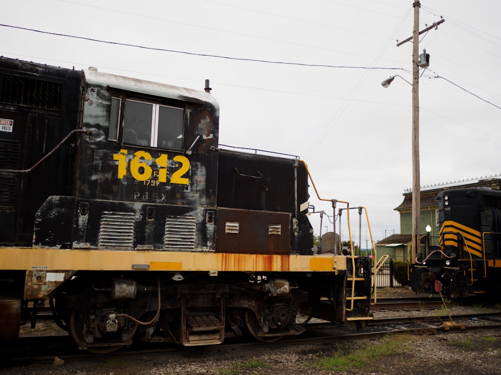 a black and yellow train sitting on the tracks