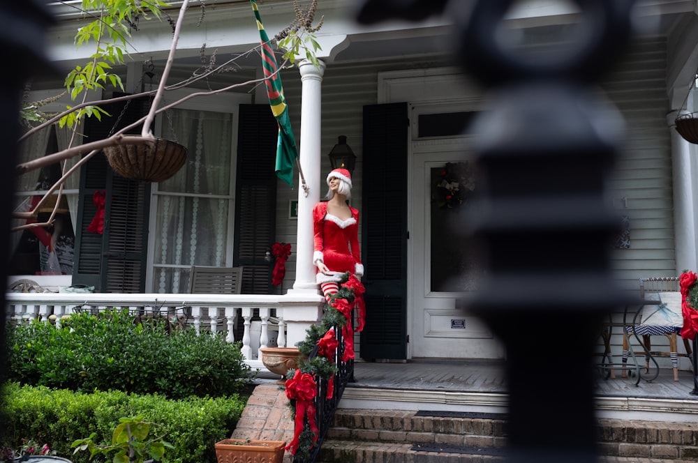 a man dressed as santa clause sitting on a porch