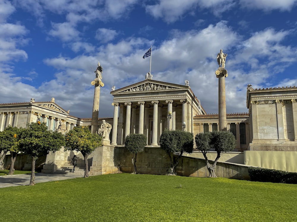 a building with columns and a flag on top of it