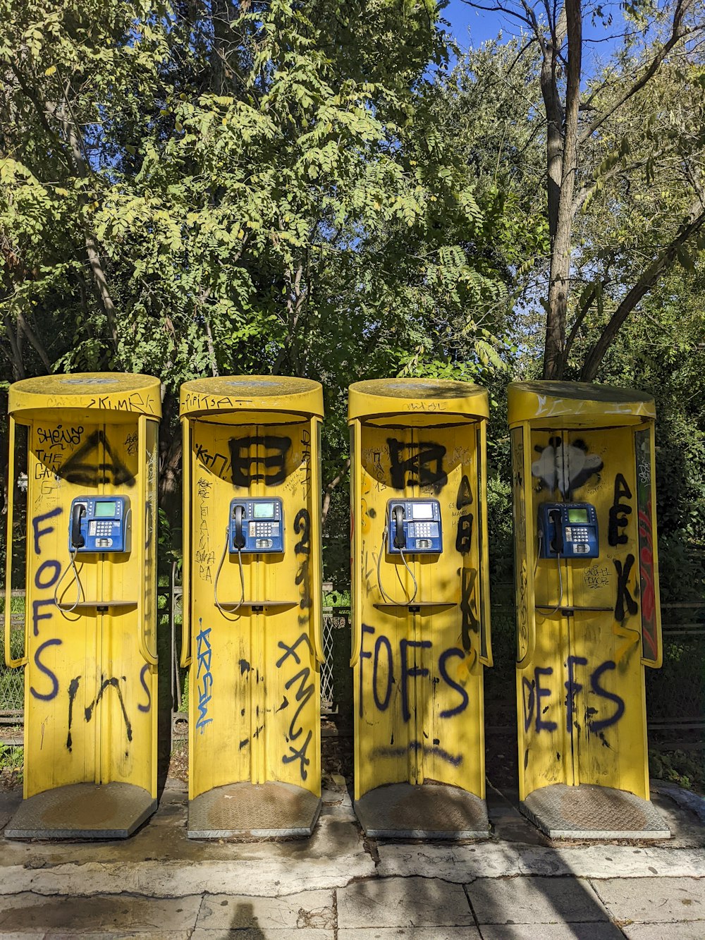 a row of yellow toilets covered in graffiti