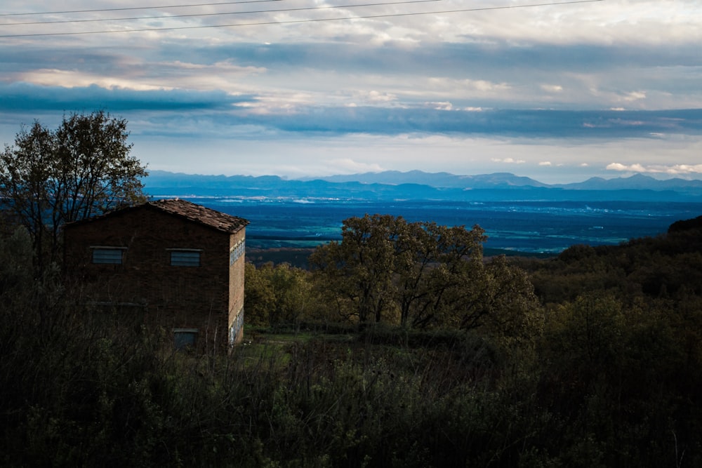 a house in the middle of a field with mountains in the background