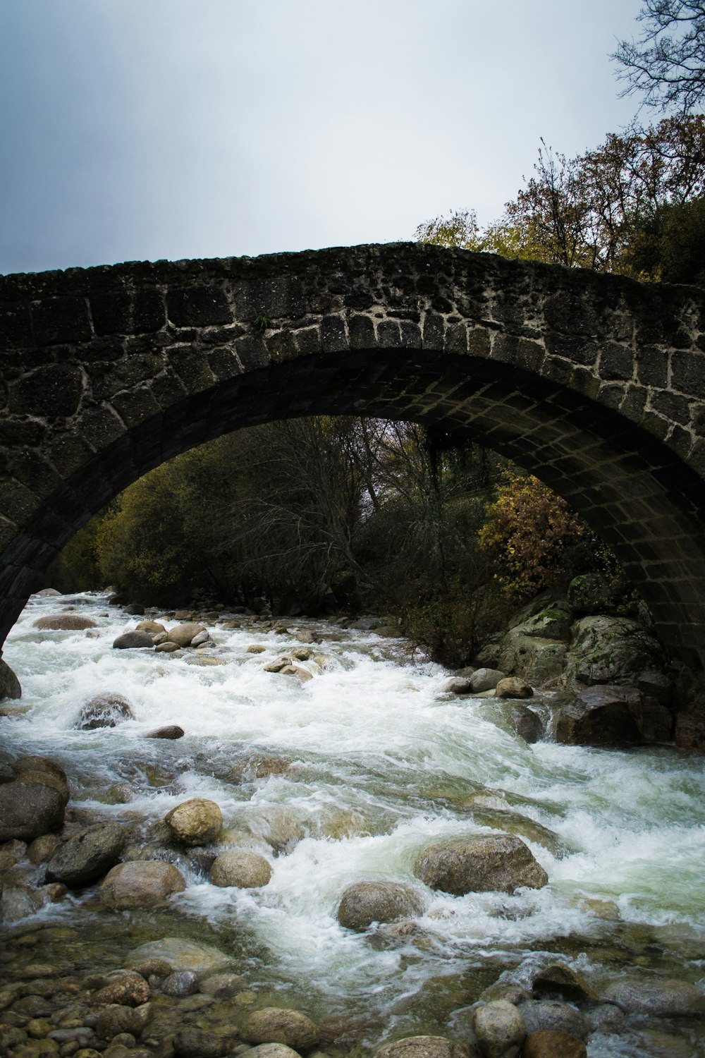 a stone bridge over a rushing river