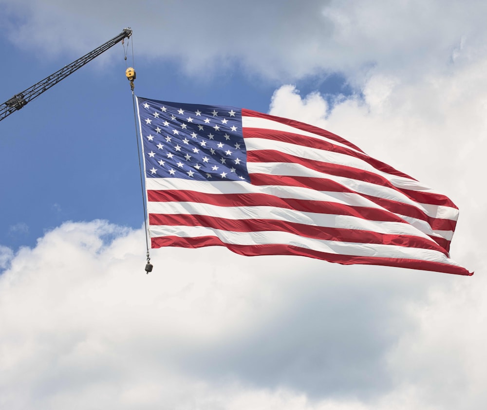 a large american flag flying in the wind