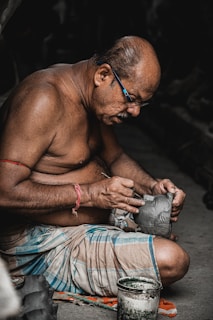 a man sitting on the ground working on something