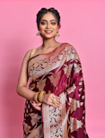 a woman wearing a maroon and gold sari