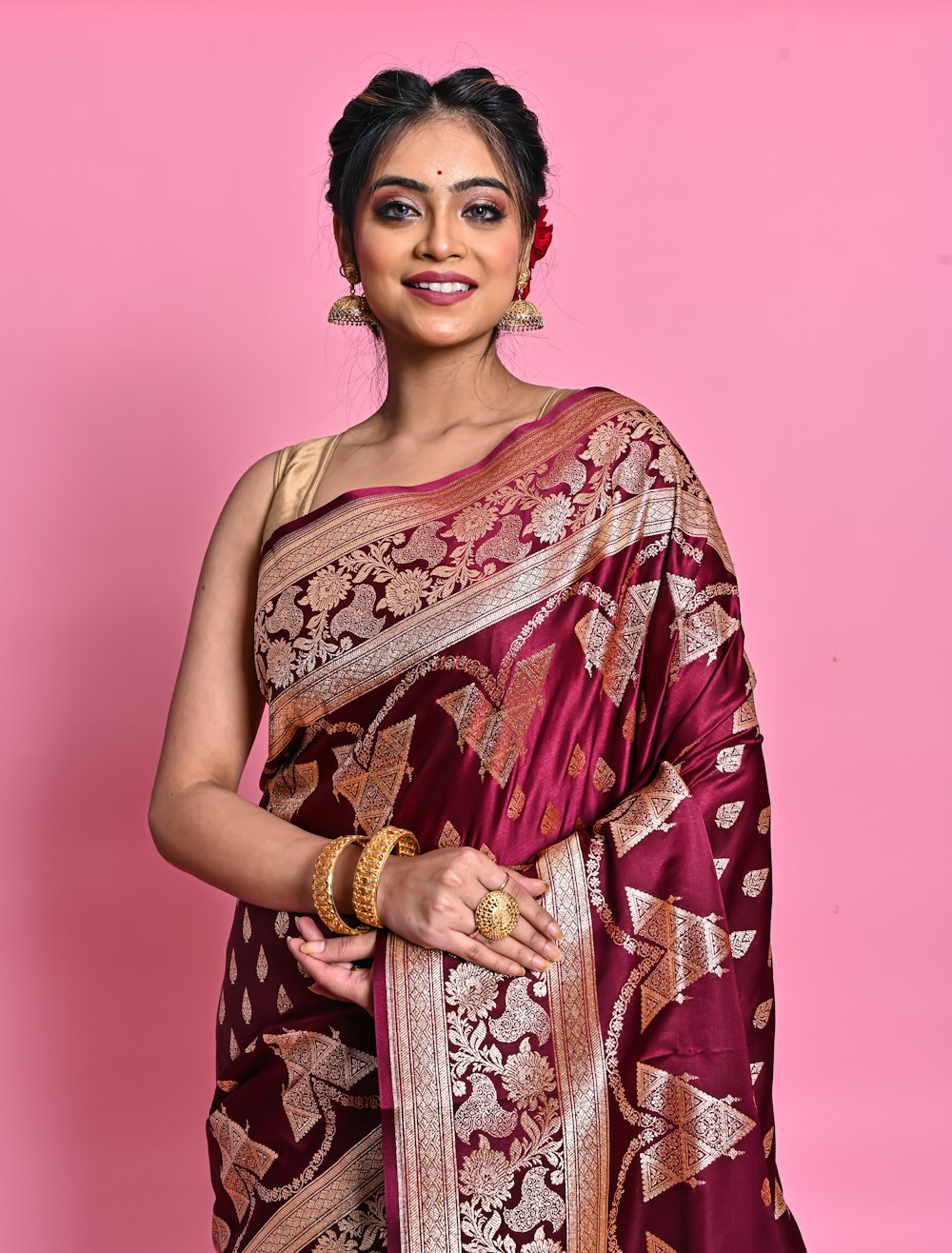 a woman wearing a maroon and gold sari