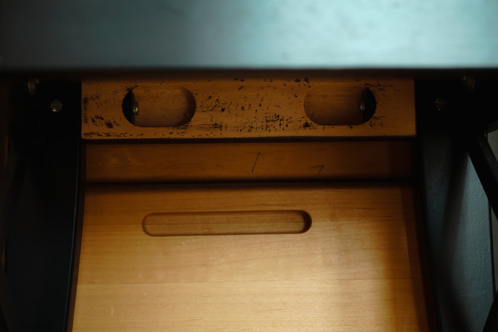a close up of a drawer with a wooden handle