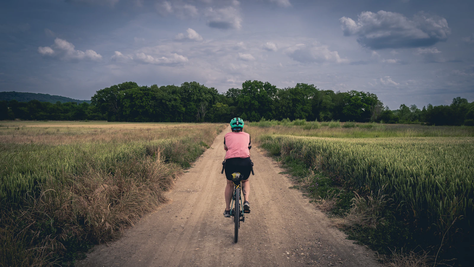 Ciclista a pedalar uma bicicleta de gravel num caminho de terra batida