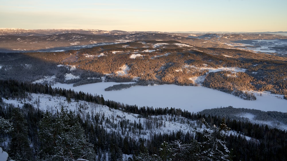 a view of a snowy mountain with trees and mountains in the background