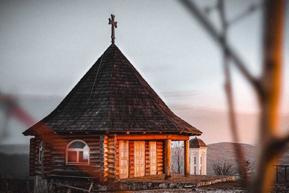 a small wooden building with a cross on top of it