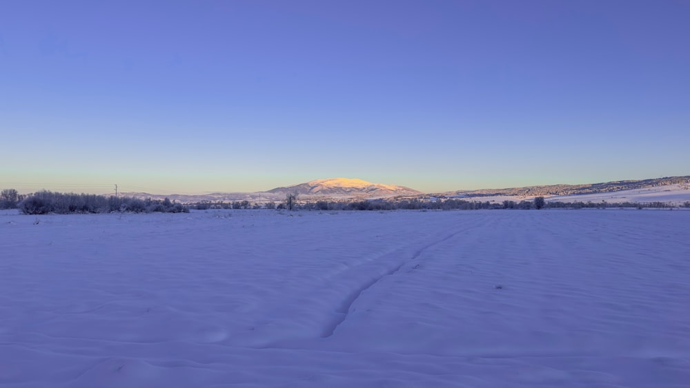 un campo cubierto de nieve con montañas en la distancia