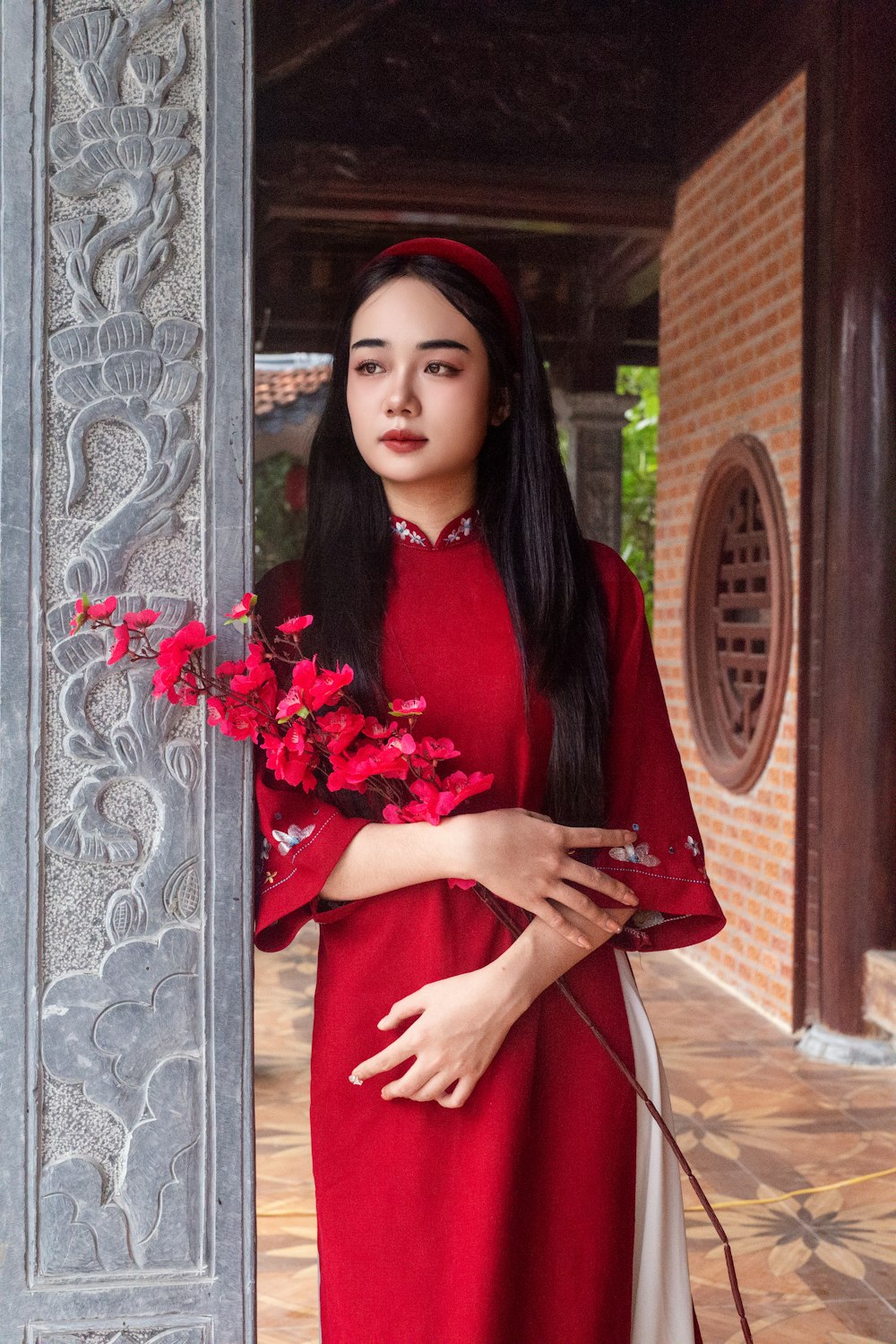 a woman in a red dress holding a bouquet of flowers