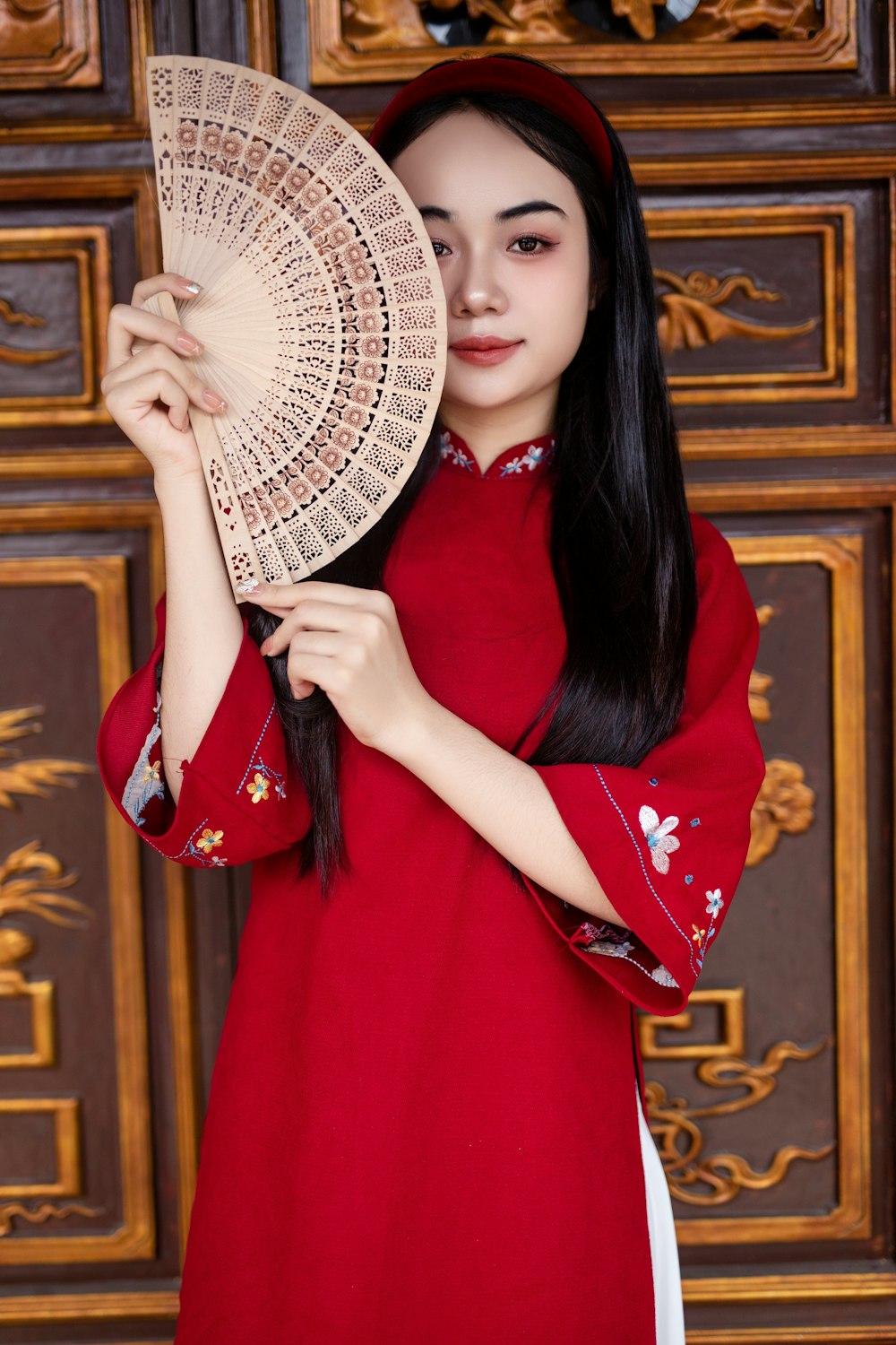 a woman in a red dress holding a fan