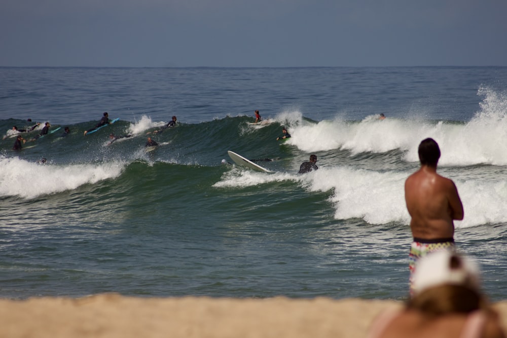 a group of people riding surfboards on top of a wave