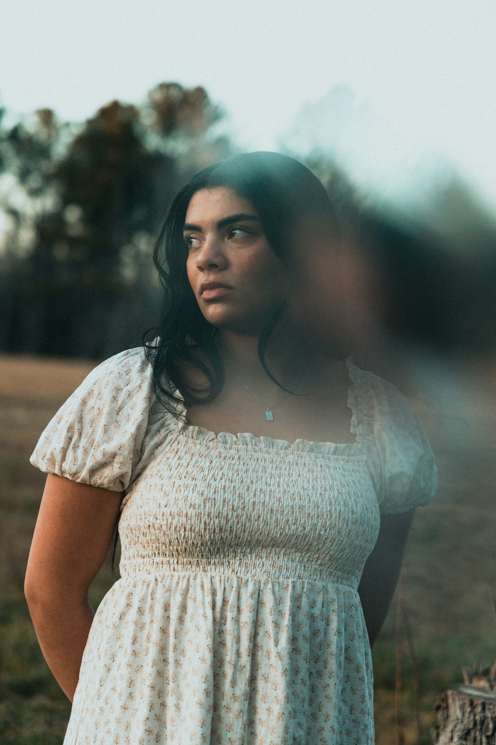 a woman in a dress standing in a field