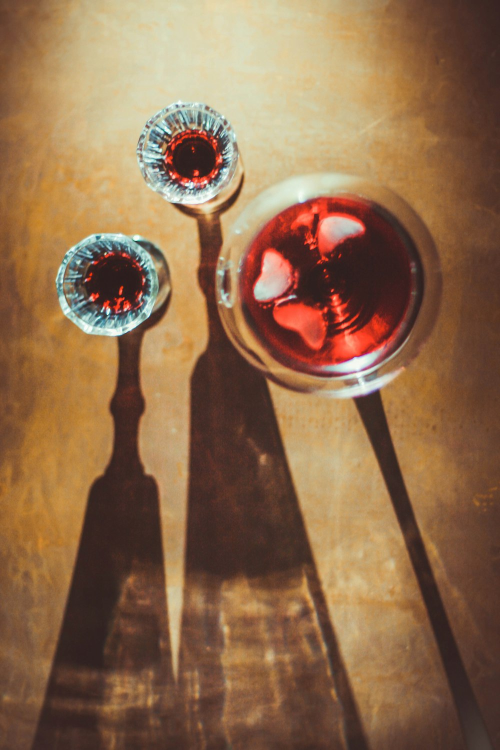 a shadow of two spoons and a glass of wine