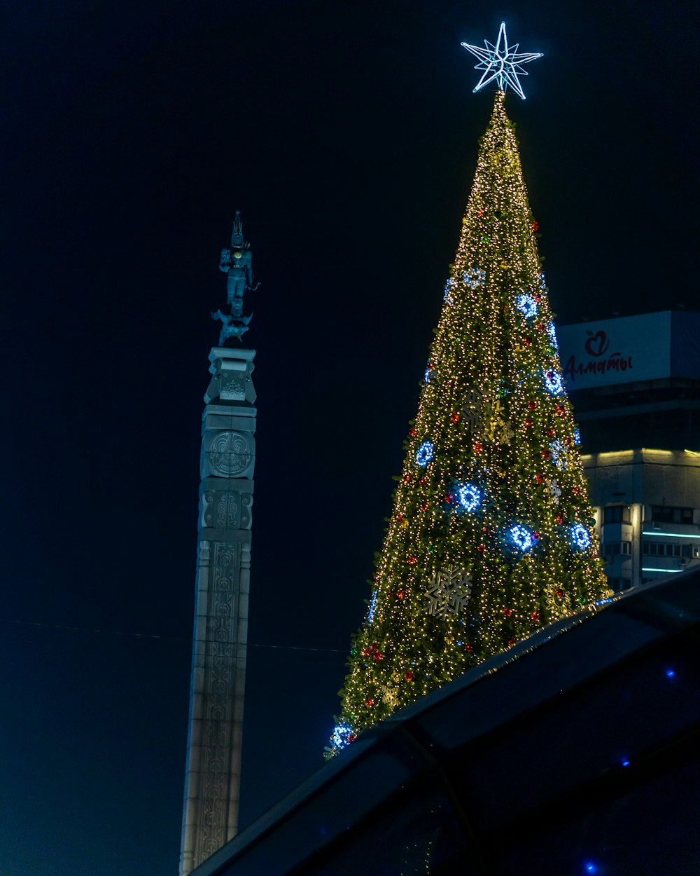 a large christmas tree in front of a tall building