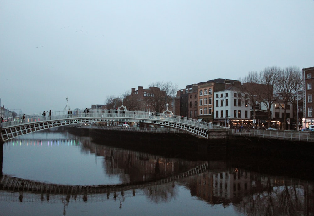 a bridge over a body of water with buildings in the background