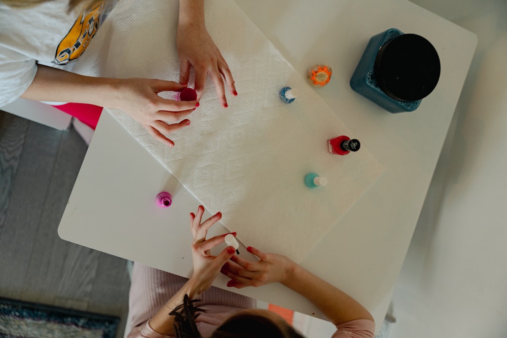 two girls are doing crafts on a table