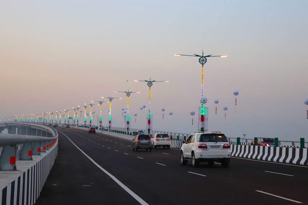 cars driving on a road with a bridge in the background