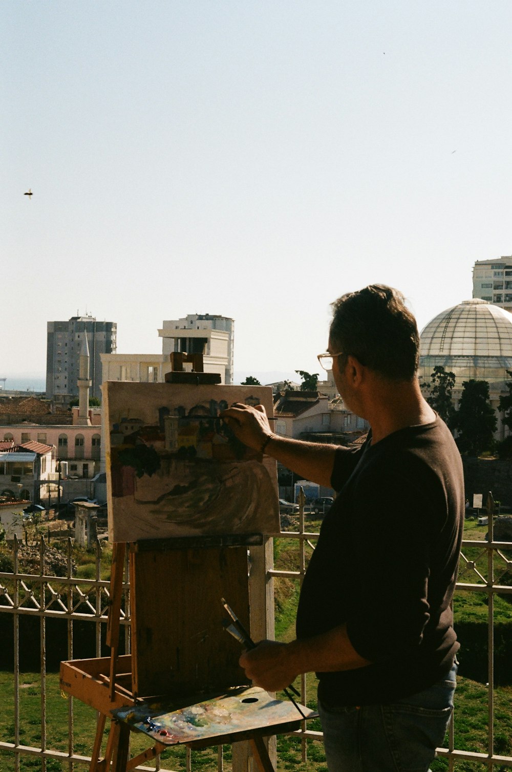 un uomo sta dipingendo un quadro su un cavalletto