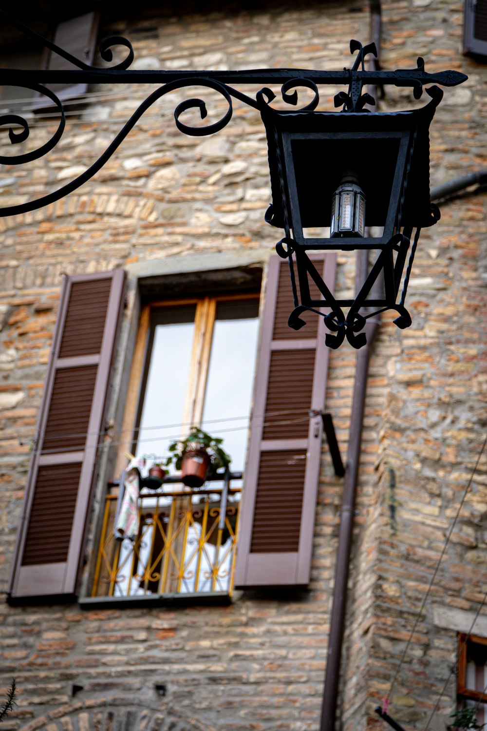 a lamp hanging from the side of a brick building