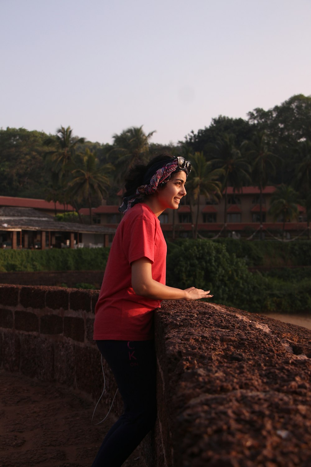 a woman leaning on a wall with a bandanna on her head