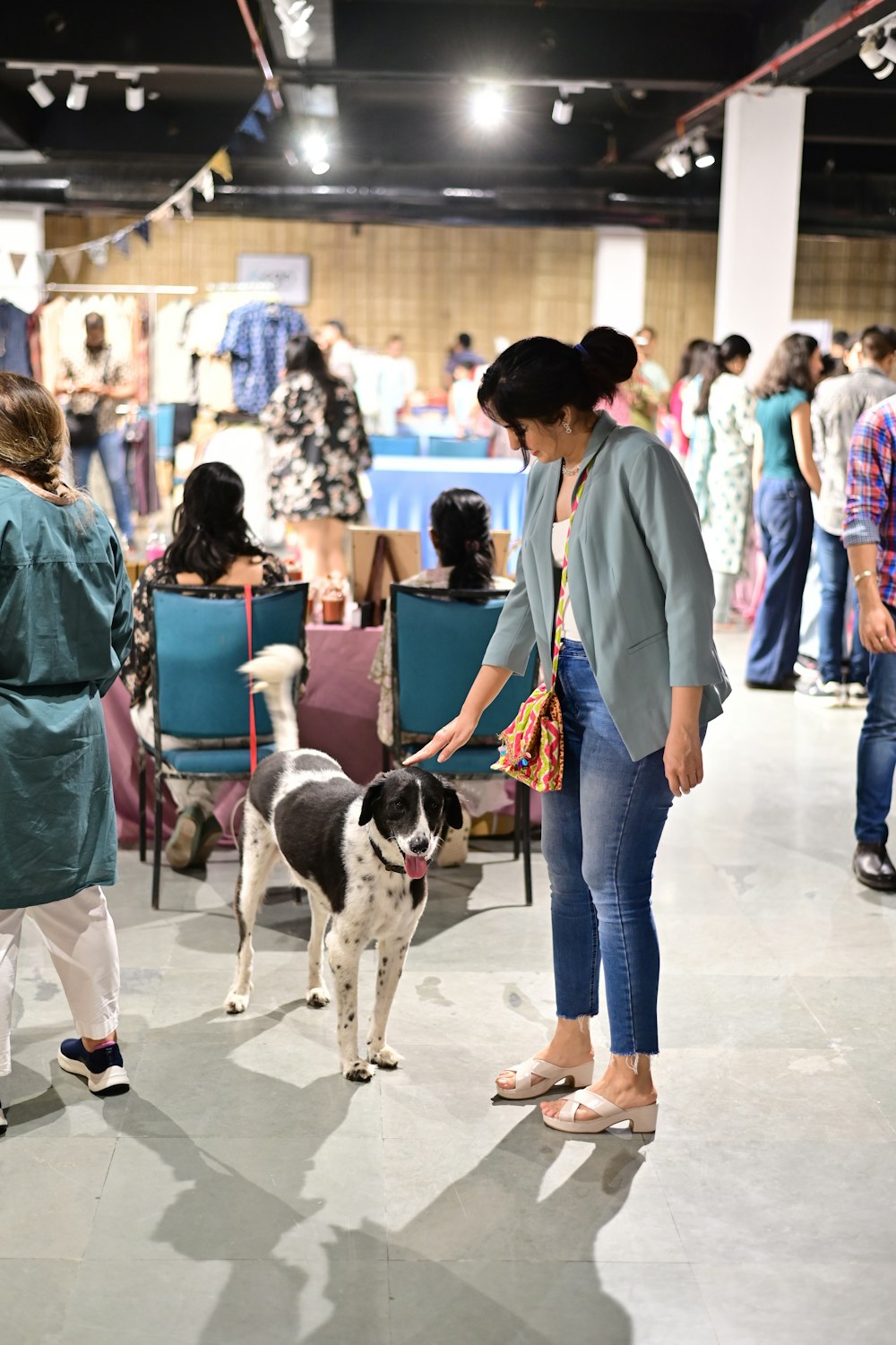 a woman standing next to a black and white dog