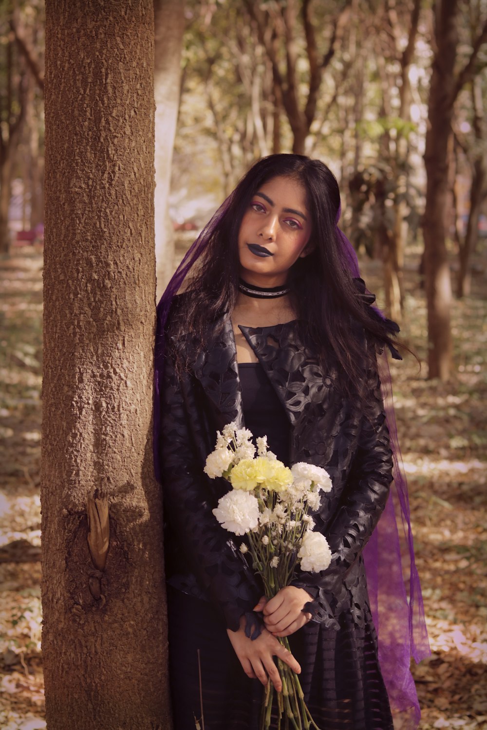 a woman in a black dress holding a bouquet of flowers