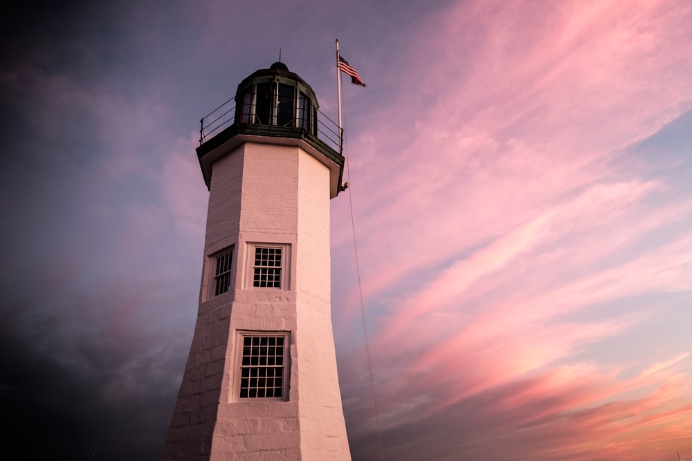 a white lighthouse with a flag on top of it