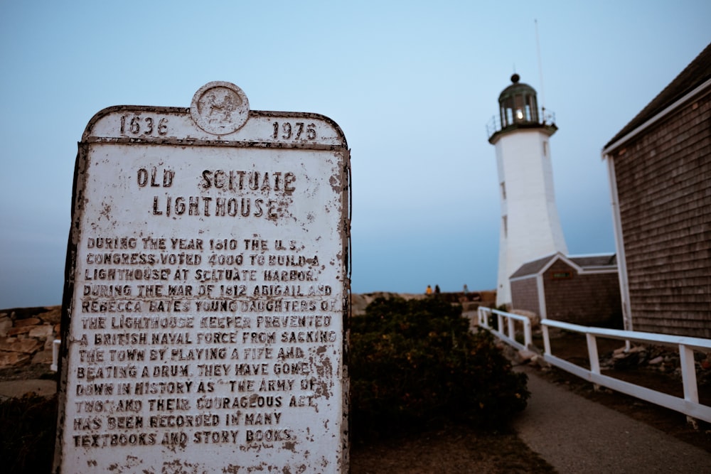 a sign that is in front of a light house