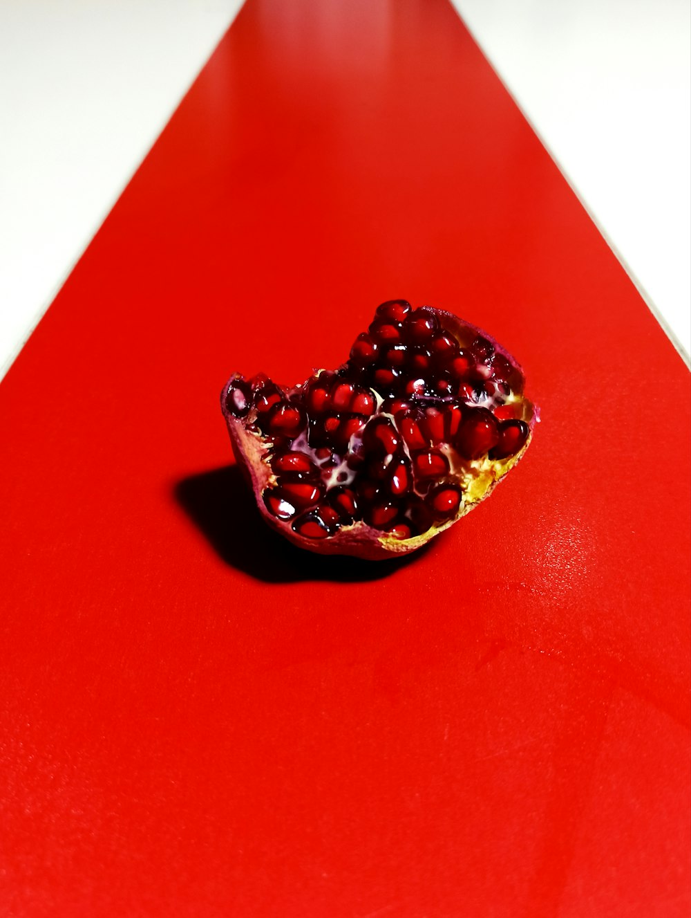 a pomegranate sitting on top of a red table