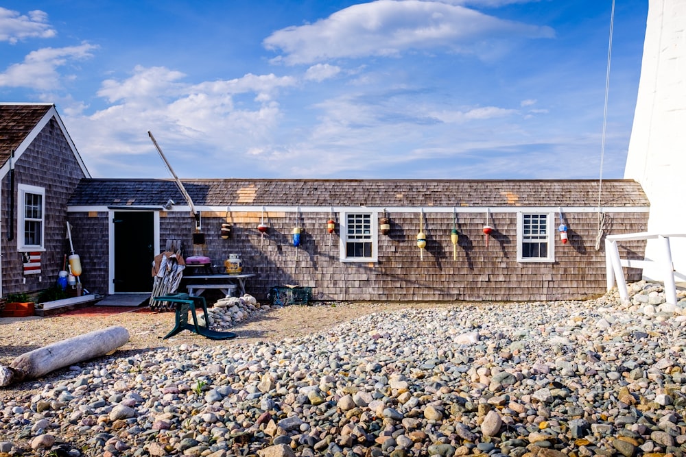 a house on a rocky beach with a picnic table in front of it