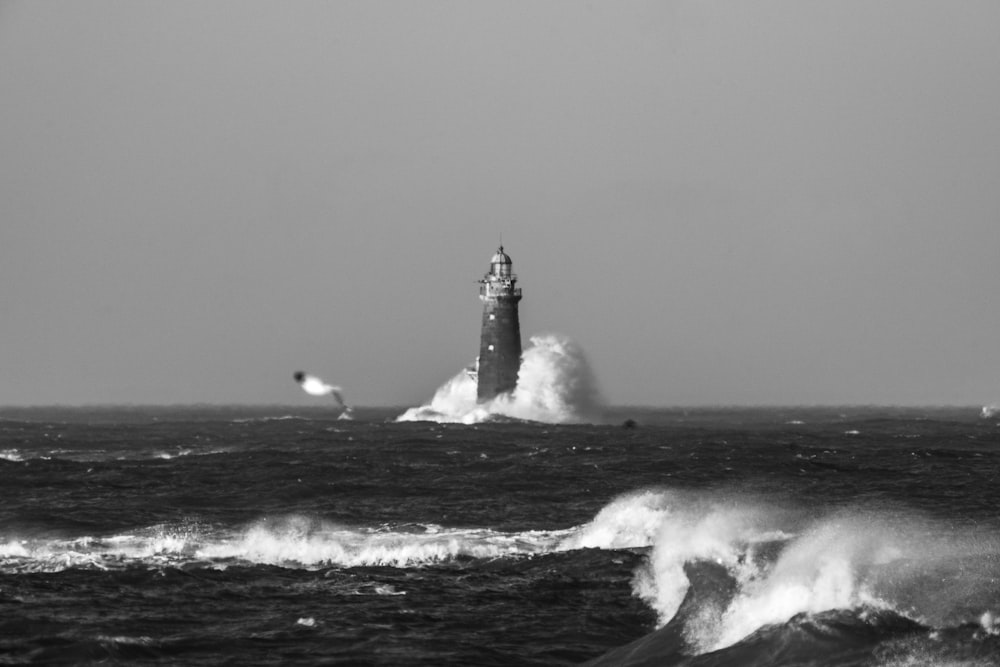 海に浮かぶ灯台の白黒写真