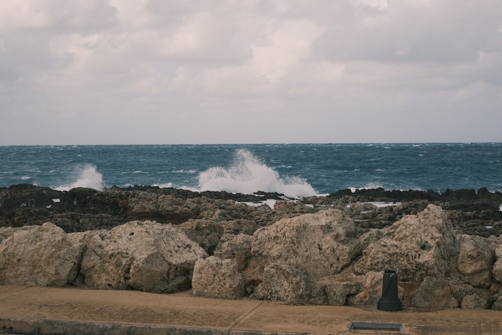 a large rock wall next to a body of water