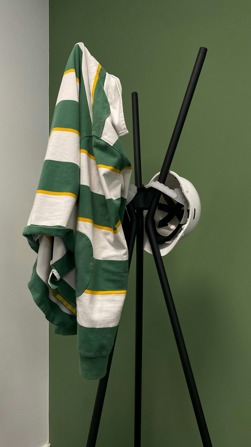 una toalla verde y blanca colgada en un perchero