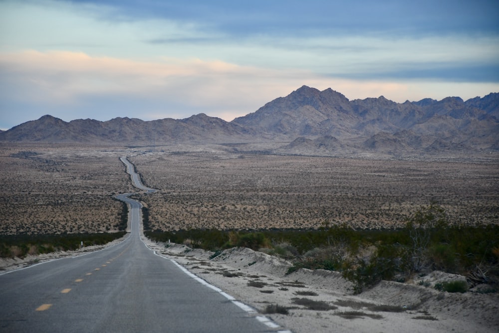 an empty road in the middle of the desert