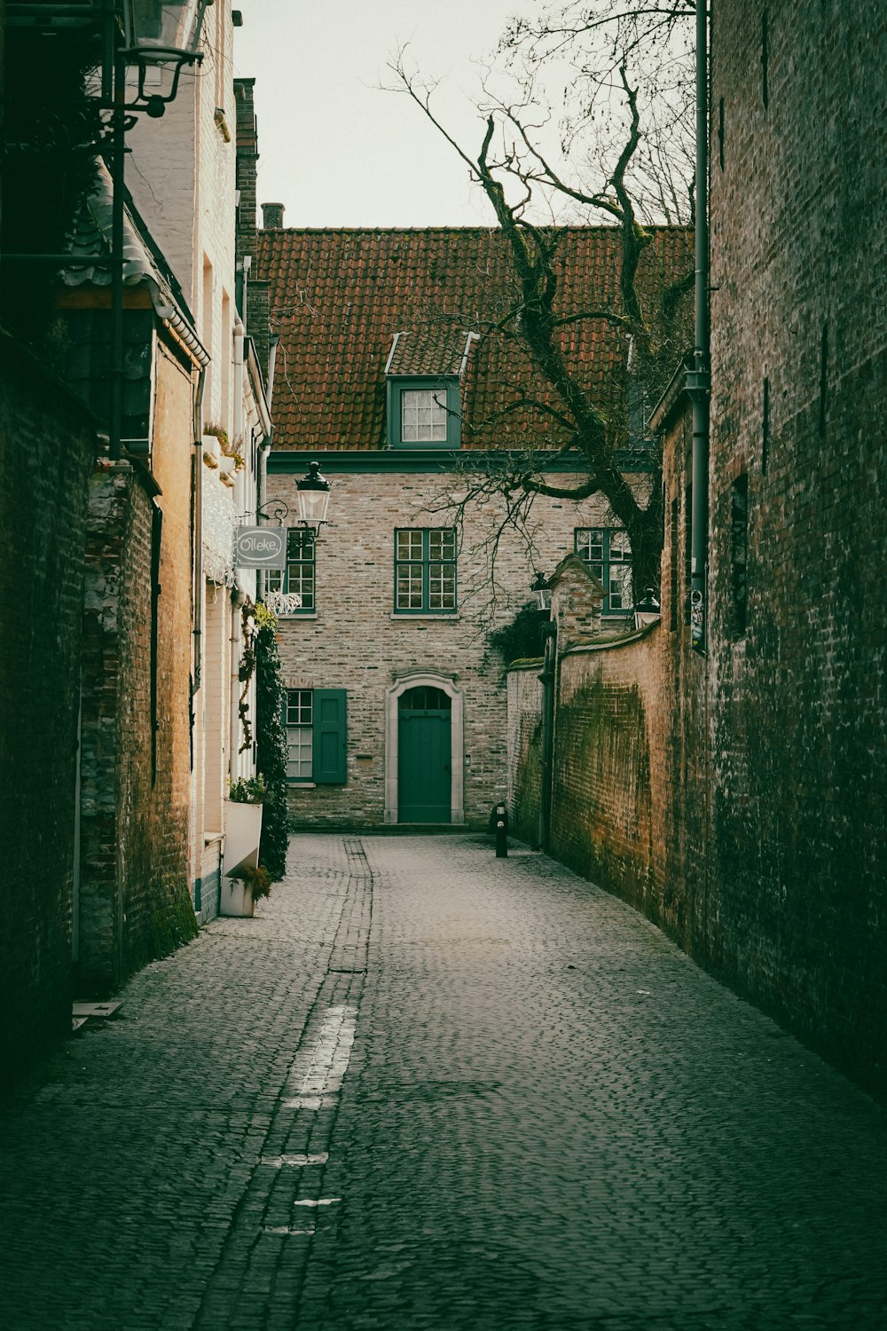 a cobblestone street with a brick building in the background