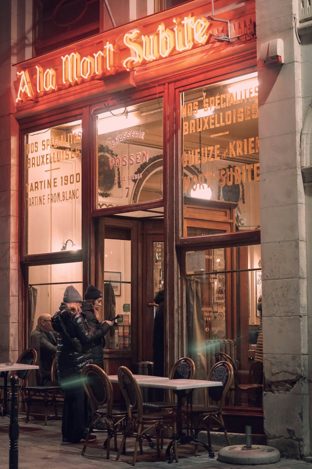 a man sitting at a table in front of a restaurant