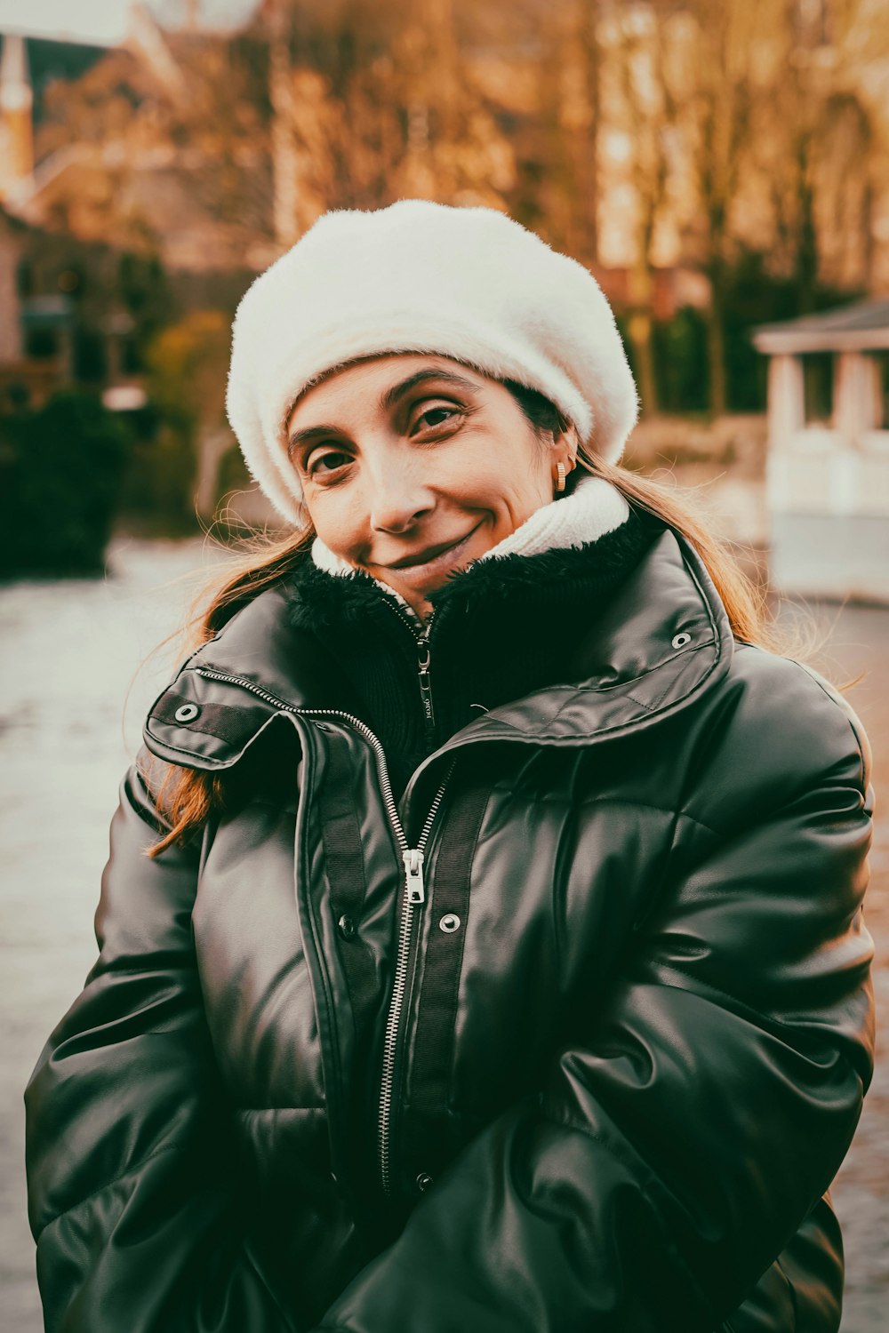 a woman in a black jacket and a white hat